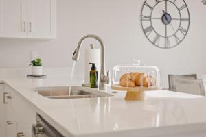 a kitchen counter with a sink and a clock on the wall at Pool, lazy river, pickle ball, sleeps 14, fire pit in Washington