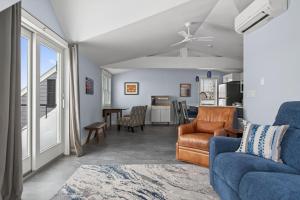 a living room with a couch and a table at Modern Waterfront Apt with Bay Views in Falmouth