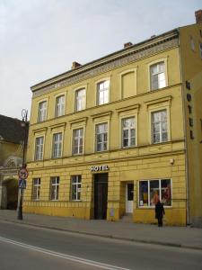 żółty budynek po stronie ulicy w obiekcie SHotels przy Restauracji Stodoła w mieście Bartoszyce