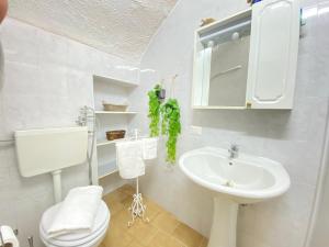 a white bathroom with a sink and a toilet at Lo Scoglio Bianco in Gallipoli