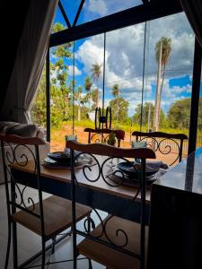 a table and chairs in a room with a large window at Cabana Quintal in Aquidauana +19 photos