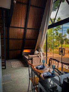 a living room with a table and chairs and a couch at Cabana Quintal in Aquidauana
