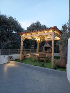 a wooden pergola with a table and chairs at Amela House in Skala Kallirachis