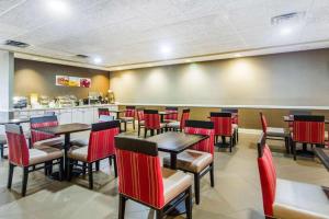 a restaurant with red chairs and tables and a counter at HOTEL WORLD Inn and Suites in Corbin