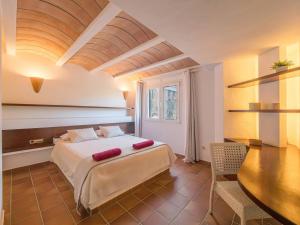 a bedroom with a bed and a table in a room at Els Tamarells Apartment by 3VILLAS in Fornells