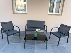 two chairs and a table with a vase with flowers at James Home in Quarto dʼAltino