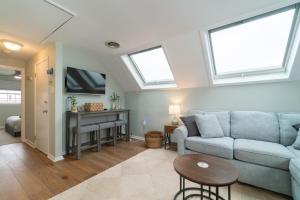a living room with a blue couch and two windows at Ocean City 2BR Condo in Ocean City