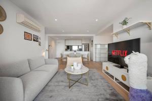 a living room with a couch and a tv at 39th floor luxurious spacious apartment in Melbourne
