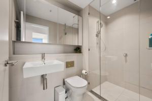 a bathroom with a toilet and a sink and a shower at 39th floor luxurious spacious apartment in Melbourne +7 photos