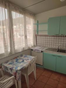 eine Küche mit Tisch, Stühlen und Spüle in der Unterkunft Attico 5 in Ustica