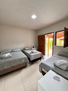 a bedroom with two beds and a table in it at Pousada e restaurante trilha da capivara in Coronel José Diaz