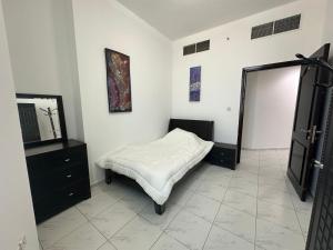 a bedroom with a bed and a dresser and a mirror at Your Comfort Starts Here in Ras al Khaimah