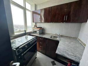 a kitchen with wooden cabinets and a sink and a window at Your Comfort Starts Here in Ras al Khaimah