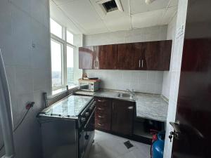 a kitchen with wooden cabinets and a sink and a window at Your Comfort Starts Here in Ras al Khaimah +8 photos