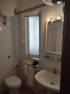 ein Badezimmer mit Toilette, Waschbecken und Spiegel in der Unterkunft Attico 5 in Ustica