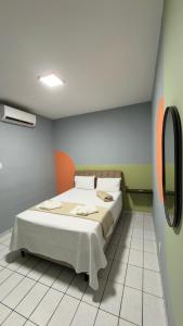 a bedroom with a bed and a mirror on the wall at Hotel Brasilia in Aracaju