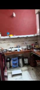 a kitchen with pots and pans and a red wall at Khanna Nagar GDA approved colony in Ghaziabad