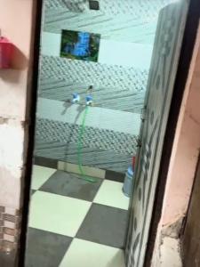 a glass door with a green hose on a tile floor at Khanna Nagar GDA approved colony in Ghaziabad