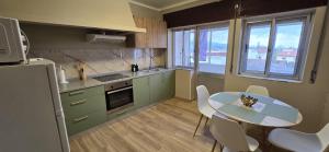 a kitchen with a table and a table and chairs at Apartamento Vila Melgaço in Melgaço
