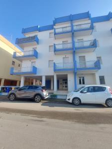 two cars parked in front of a building at La Pilozza Guest Rooms in Gallipoli