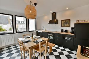 a kitchen with a table and chairs in a kitchen at Ty Dag - Terre de bas - plein centre parking privé in Roscoff