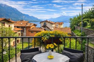 a table on a balcony with a view of a city at Il Gerlo in Lezzeno