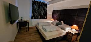 a bedroom with a bed with two pillows and a table at Zafibo Gästehaus in Quickborn