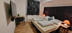 a bedroom with a large bed and a desk at Zafibo Gästehaus in Quickborn