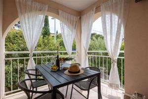 a table and chairs on a balcony with a window at Apartman David in Postira +13 photos