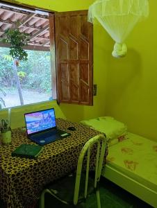 a laptop computer sitting on a table in a room at Casa oblíqua no Vale do Capão in Palmeiras