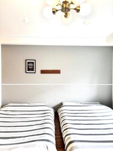 a bedroom with two beds and a ceiling at Guest House Re-worth Yabacho1 202 in Nagoya
