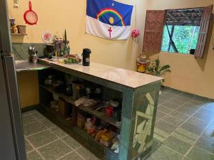 a kitchen with a counter with a rainbow on the wall at Casa oblíqua no Vale do Capão in Palmeiras