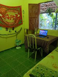 a room with a table with a laptop on it at Casa oblíqua no Vale do Capão in Palmeiras +4 photos