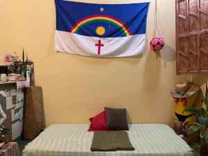 a flag hanging on a wall next to a bed at Casa oblíqua no Vale do Capão in Palmeiras