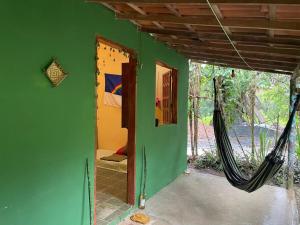 a room with a bed and hammock in it at Casa oblíqua no Vale do Capão in Palmeiras