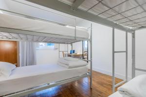 a bedroom with two bunk beds and a table at HI Coimbra - Pousada de Juventude in Coimbra