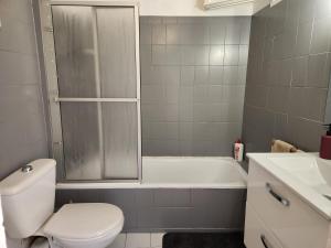a bathroom with a toilet and a tub and a sink at French Cocoon in Fayence