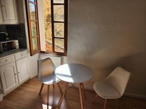 a table and two chairs in a kitchen with a window at French Cocoon in Fayence