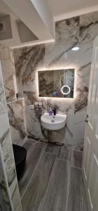 a bathroom with a white sink and marble walls at Zafibo Gästehaus in Quickborn +29 photos