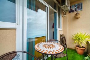 a patio with a table and chairs on a balcony at El Nido in Gavà