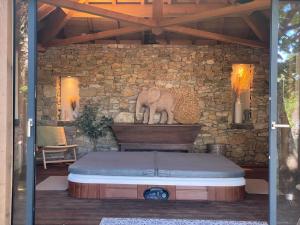 a room with a stone wall with a bed at LE PRESBYTERE in Chasnay