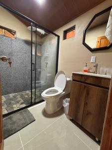 a bathroom with a toilet and a glass shower at Nature retreat in Río Cuarto
