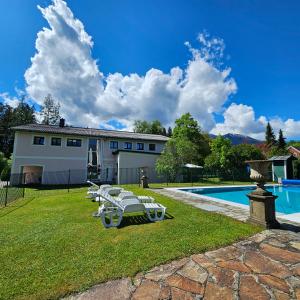 a house with a pool and lounge chairs in the yard at Ferienwohnung Blick ins Grüne in Rossleithen