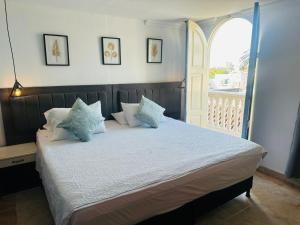 a bedroom with a bed with pillows and a window at Hotel Marie Real Cartagena in Cartagena de Indias