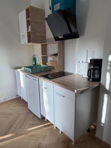 a kitchen with white cabinets and a counter top at Apartamento Villuercas in Cañamero +6 photos