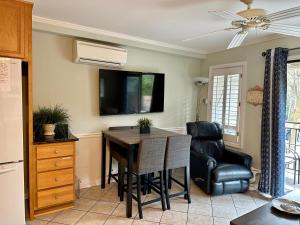 a kitchen with a dining room table and a television at Seaside 190 in Hilton Head Island