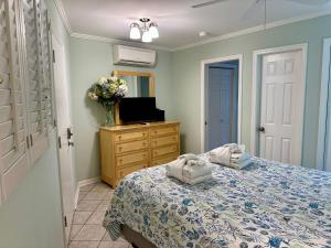 a bedroom with a bed and a tv and a dresser at Seaside 190 in Hilton Head Island +50 photos
