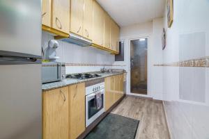 a kitchen with wooden cabinets and a stove top oven at El Nido in Gavà