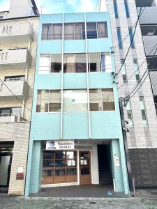 a blue building with a sign in front of it at Guest House Re-worth Yabacho1 202 in Nagoya