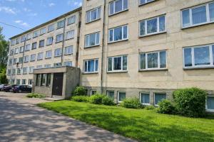 a large brick building with a lawn in front of it at Rohu Apartment in Pärnu